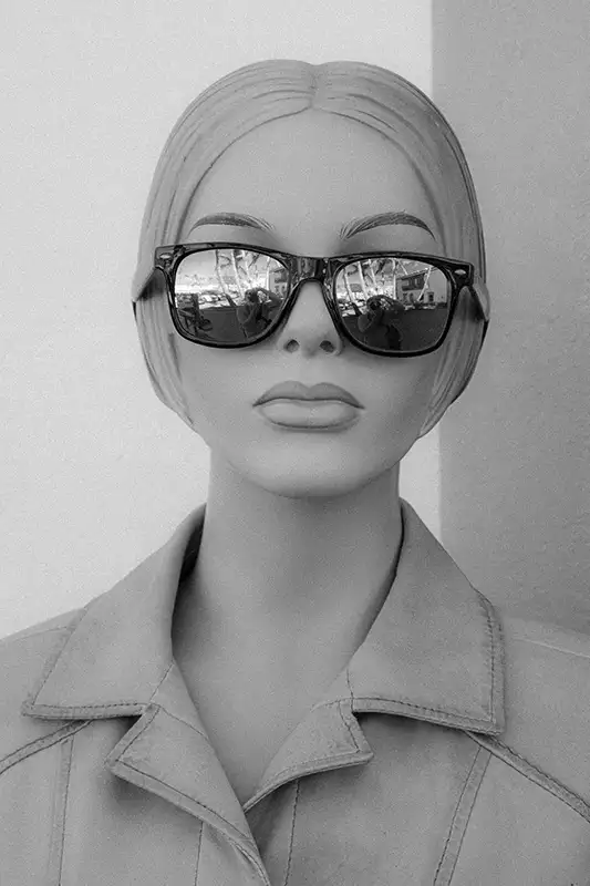 Woman wearing fashion sunglasses looking right at the camera.