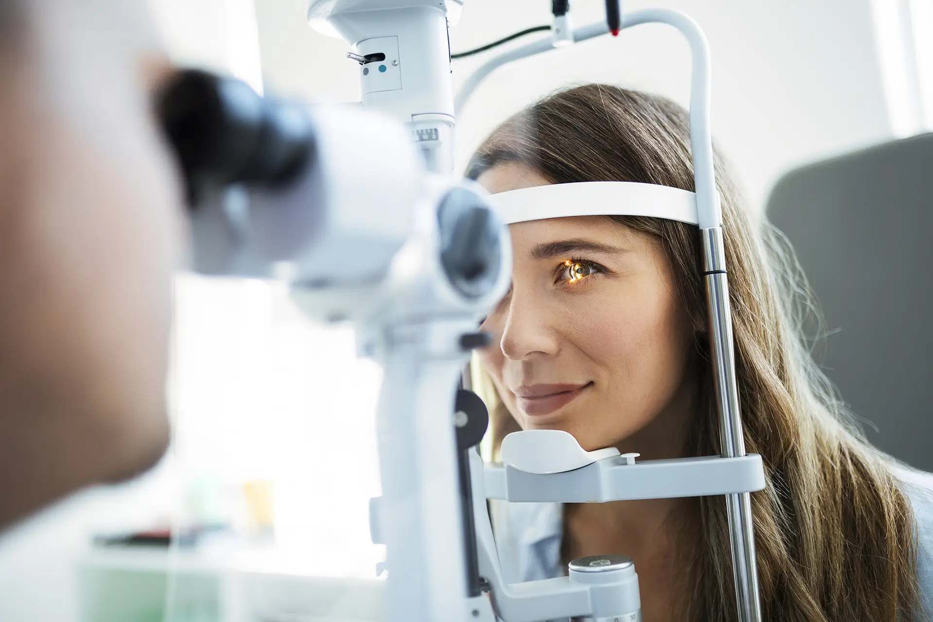 Young woman getting an eye exam from an optometrist.